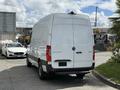 A 2022 Mercedes-Benz Sprinter van in white facing away with a high roof and a rear sliding door