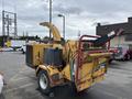 A 2015 Vermeer Corporation BC1200XL wood chipper with a yellow and black exterior featuring a feed hopper and discharge chute for chipping wood and brush