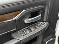 Interior door panel of a 2024 RAM 5500 showing the armrest window control buttons and handle with a textured black finish and wood accents