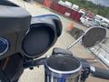 A close-up view of the handlebars and instrument cluster of a 2017 Harley-Davidson FLHTKL with a speaker and mirrors visible