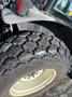 Close-up of a large agricultural tire showcasing a rugged tread pattern and white rim typical of a 2010 New Holland T4050 tractor