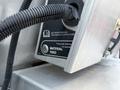 Close-up of the control panel on a 2023 Ford F-250 featuring a material feed button and a label indicating to press both buttons to operate