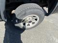 The image shows a close-up of a tire mounted on a 2014 GMC Sierra 1500 with a silver wheel rim and textured tread pattern
