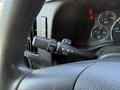 Close-up of the turn signal and headlight control lever on the steering column of a 2020 Chevrolet Express van