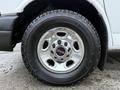 Close-up of a chrome wheel with a GMC logo on a 2016 GMC Savana tire showing tread details
