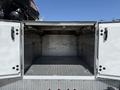 A 2020 Ram 2500 truck with an open utility bed revealing a spacious, empty storage area with diamond plate flooring and side compartments
