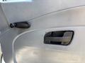 Close-up of the door panel of a 2011 International 4300 featuring a crank handle for manual window operation and a pull handle for opening the door