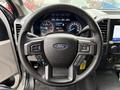 Steering wheel of a 2020 Ford F-550 with controls for cruise and audio settings visible on the spokes