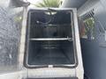 An empty compartment with a diamond plate interior inside a vehicle with metal walls and a sliding door