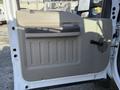 The image shows the interior door panel of a 2008 Ford F-550 featuring a beige plastic finish with a small vent and a handle
