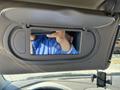 A 2006 Pontiac G6 sun visor with a flip-up mirror revealing a person's hand holding a phone