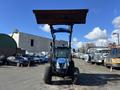 A blue 2010 New Holland T4050 tractor with a raised front loader bucket facing forward