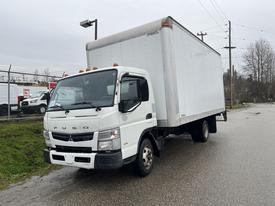 A 2012 Mitsubishi Fuso FE truck with a white box cargo container parked on a street