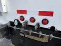 The rear of a 2011 International 4300 featuring three red lights a blue connector and a row of bolts securing the chassis