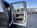 A 2020 Ford F-550 truck with the driver's side door open, showcasing the interior and door panel design