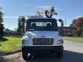 A 2005 Freightliner M2 106 truck with a white body and a mounted aerial lift on top facing forward