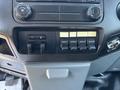 Control panel of a 2011 Ford F-550 featuring various switches and knobs for auxiliary functions and climate control