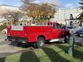 Red 2013 Chevrolet Silverado 3500HD pickup truck with a metal utility bed and side racks parked on grass