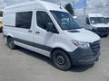 A 2022 Mercedes-Benz Sprinter van in white with a black front bumper and wheels parked at a lot