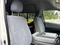 Interior of a 2009 Toyota Hiace showing two light grey fabric seats a central console and a headrest in the driver's seat