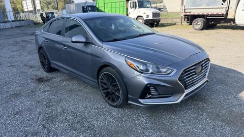 A gray 2018 Hyundai Sonata with a sleek design and sporty black wheels positioned at an angle