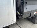 A close-up of the rear of a 2015 Mitsubishi Fuso FE160 truck showing the latch mechanism and a portion of the bed with a tire visible