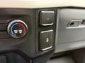 A close-up of the control panel in a 2021 Ford F-150 featuring air conditioning controls and a 12V power outlet