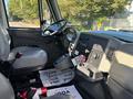 The interior of a 2013 International 7500 truck featuring a driver's seat dashboard controls and various levers and switches
