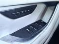 Interior door panel of a 2020 Jaguar XE featuring seat memory buttons and window controls with a sleek design in a light leather finish