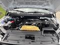 The engine compartment of a 2020 Ford F-150 showing the engine block battery and various components including hoses and fluid reservoirs