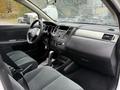 Interior of a 2012 Nissan Versa featuring a steering wheel dashboard and front seats with gray upholstery