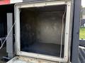 A truck cargo space of a 2010 International 4300 with an empty and clean interior featuring black walls and no visible contents
