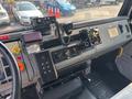 Interior dashboard of a 1999 Freightliner FL80 featuring steering wheel control panel gear shifter and various gauges and buttons