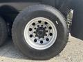Close-up of a steel wheel and tire from a 2013 International WorkStar featuring multiple lug nuts and a deep tread pattern