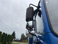 A blue 2017 Autocar Xpert truck featuring a side mirror and a mounted black cylindrical component on its driver side