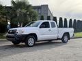 A white 2013 Toyota Tacoma pickup truck is parked at an angle with a cab and open bed facing the viewer