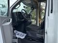 Interior of a 2020 Chevrolet Express showing black driver's seat dashboard and steering wheel with a fan and a piece of paper on the floor