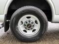 A close-up view of a 2023 GMC Savana wheel featuring a silver rim with a red GMC logo and a black Michelin tire