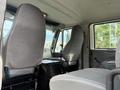 Interior view of a 2008 International 4300 cab showing two gray upholstered seats and a black storage compartment between them