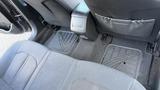 The interior of a 2018 Hyundai Sonata showing gray upholstery and floor mats in the back seat area