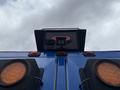 A blue 2013 International DuraStar 4300 truck seen from below with amber lights and a camera mounted on the rear