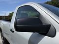 A side view of a silver 2016 Chevrolet Silverado 2500HD truck highlighting the side mirror and door handle