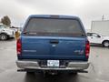 A blue 2006 Dodge Ram 2500 with a heavy-duty truck bed and 4x4 emblem visible on the tailgate