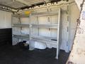 A 2017 Chevrolet Express van with metal shelving units installed in the cargo area