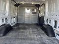 Interior view of a 2017 Ford Transit cargo van showing bare metal walls and a rubber floor with partitions and metal grilles in the rear area