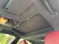 The interior of a 2016 Maserati Ghibli showing a suede ceiling and red leather seats with an overhead light panel