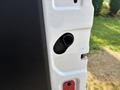 The image shows a close-up of the door latch mechanism on a 2016 Ford Transit 150 with a white panel and black interior trim