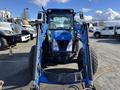A blue 2010 New Holland T4050 tractor with a front loader and large tires facing forward