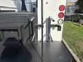 A 2005 Freightliner M2 106 with a textured black platform featuring two vertical bars and a set of steps visible on the side
