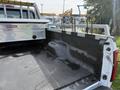 A 2011 Ford F-350 SD pickup truck with a silver diamond plate bed liner and metal bed rails